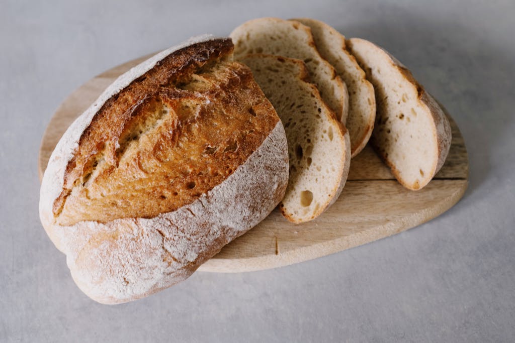 Home Sliced sourdough bread on a wooden board showcasing its texture and freshness.